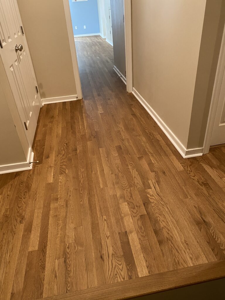 Wooden hallway floor leading to rooms.