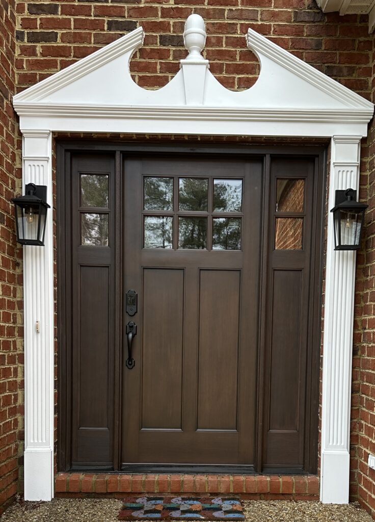 Wooden front door with brick and lanterns.