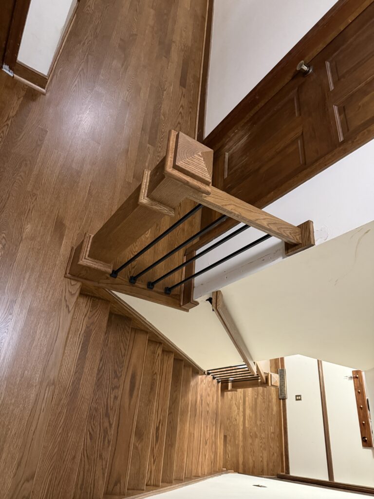 Wooden staircase with metal railings indoors.