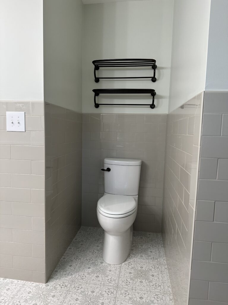 Bathroom with toilet and towel racks.