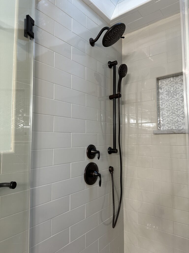 Modern shower with dark fixtures and tiles.