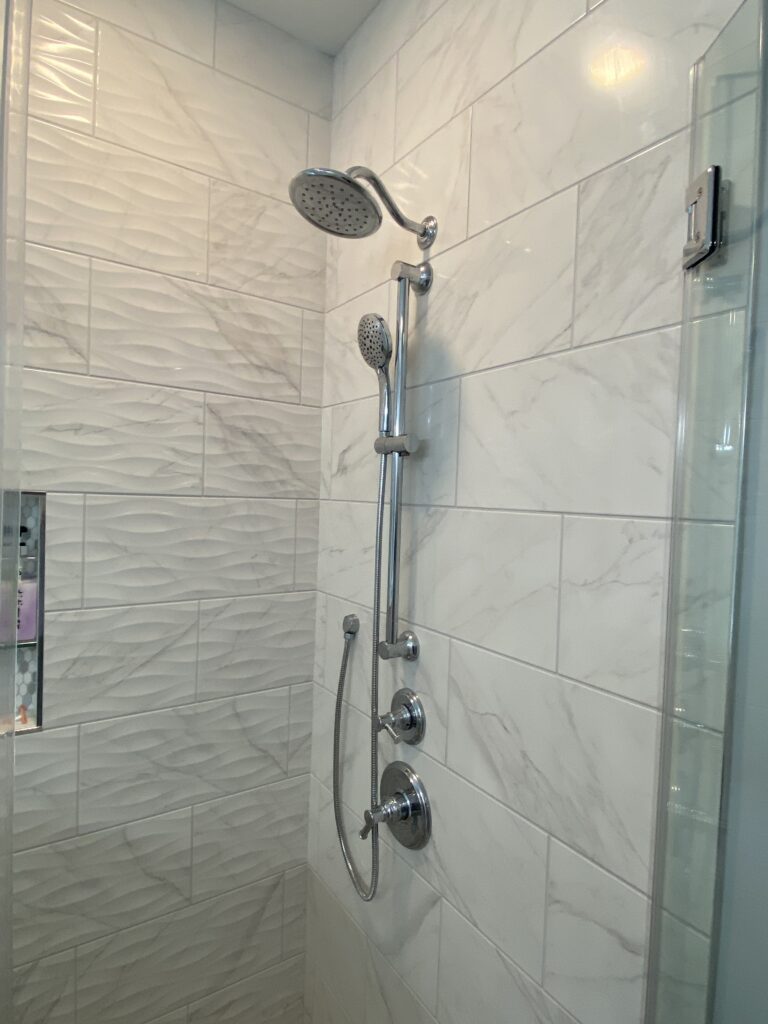 Modern shower with dual showerheads and tiles.