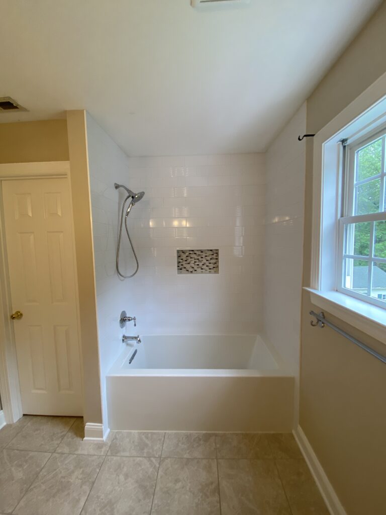 Modern bathroom with a bathtub and window.