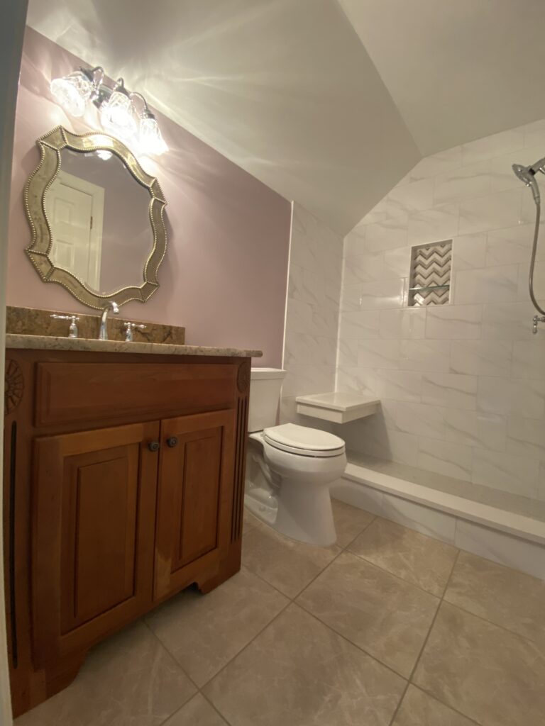 Modern bathroom with wooden vanity and mirror.