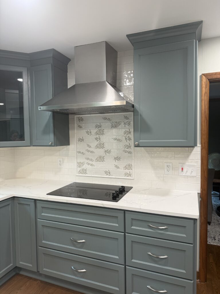 Modern kitchen with teal cabinets and stove.