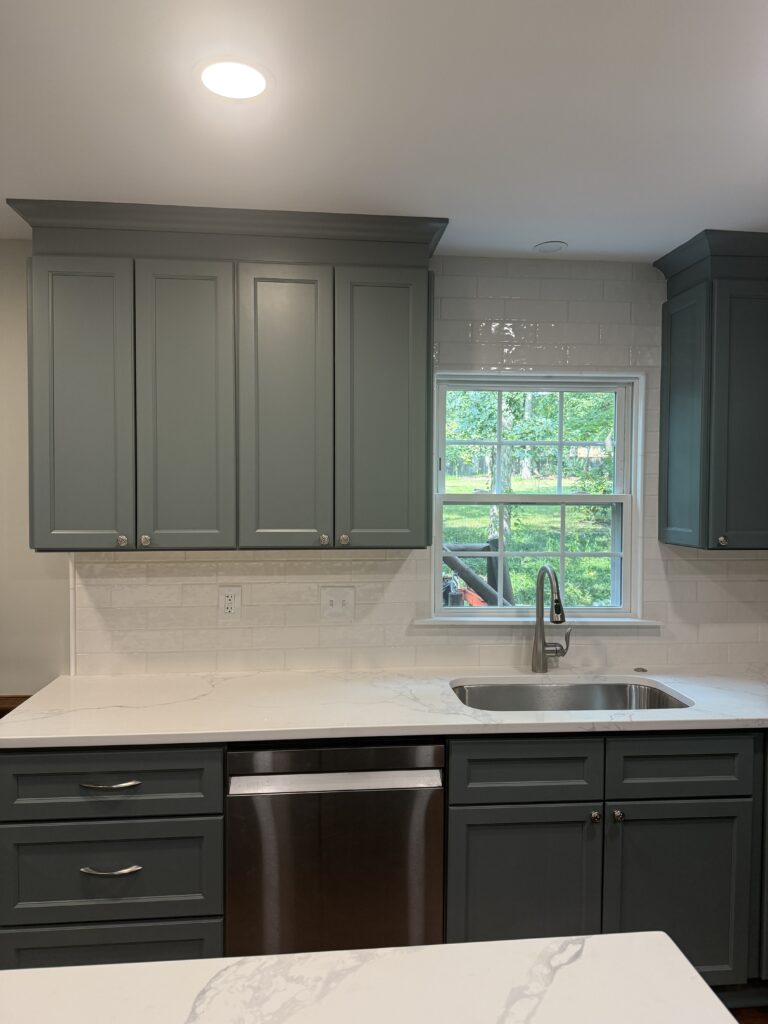 Modern kitchen with gray cabinets and window.