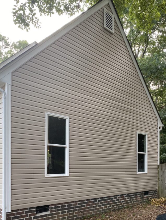 House with beige siding and two windows.