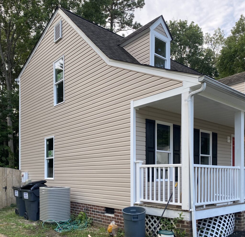 Two-story beige house with small porch.