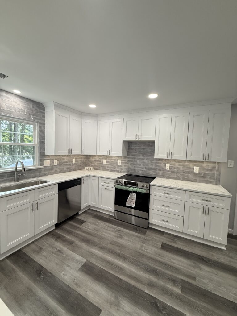 Modern kitchen with white cabinets and appliances.