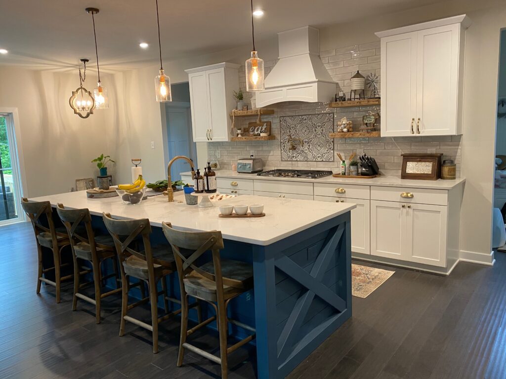 Modern kitchen with blue island and stools.