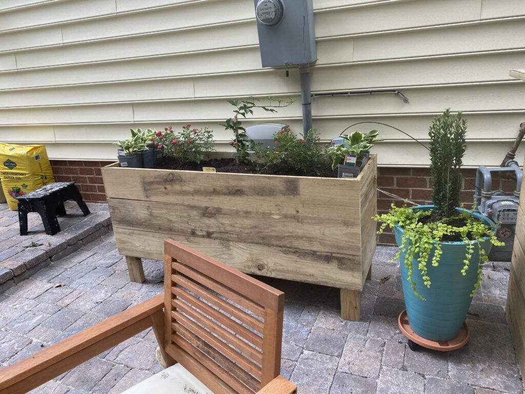 Wooden planter box on a patio.