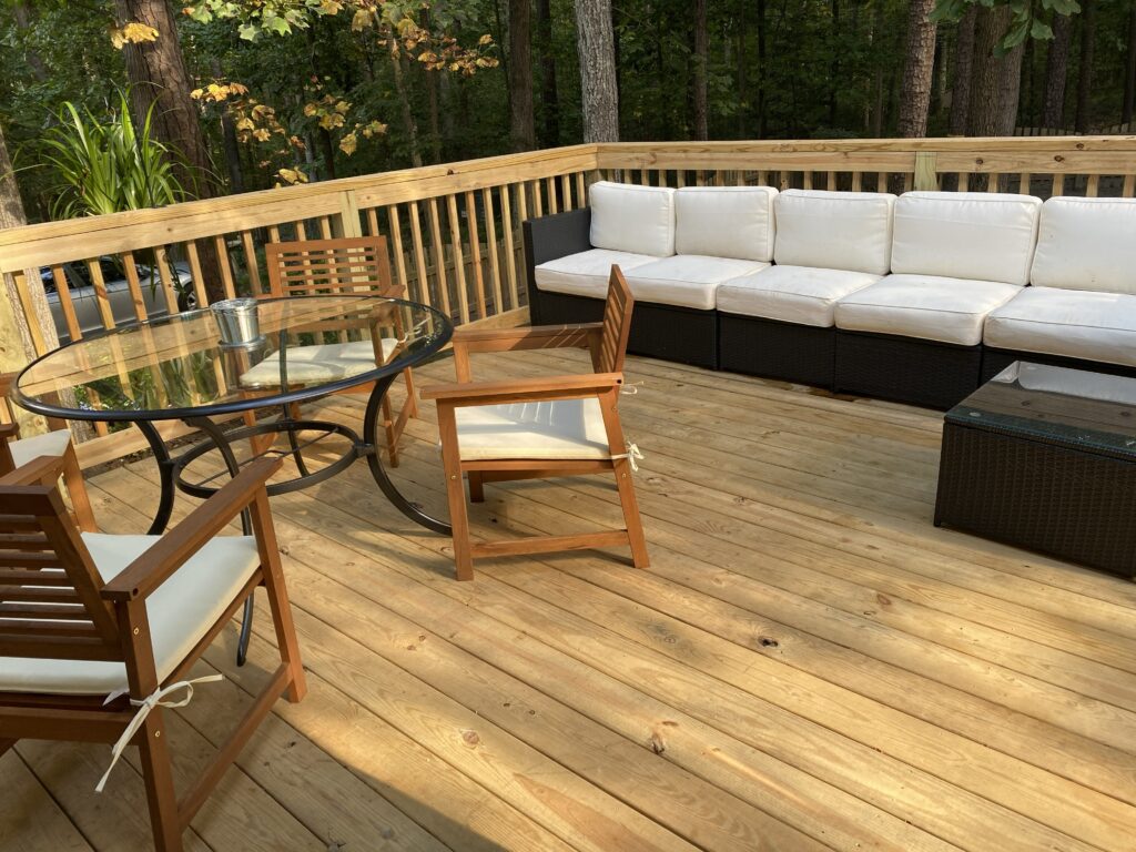 Wooden deck with outdoor seating and table.