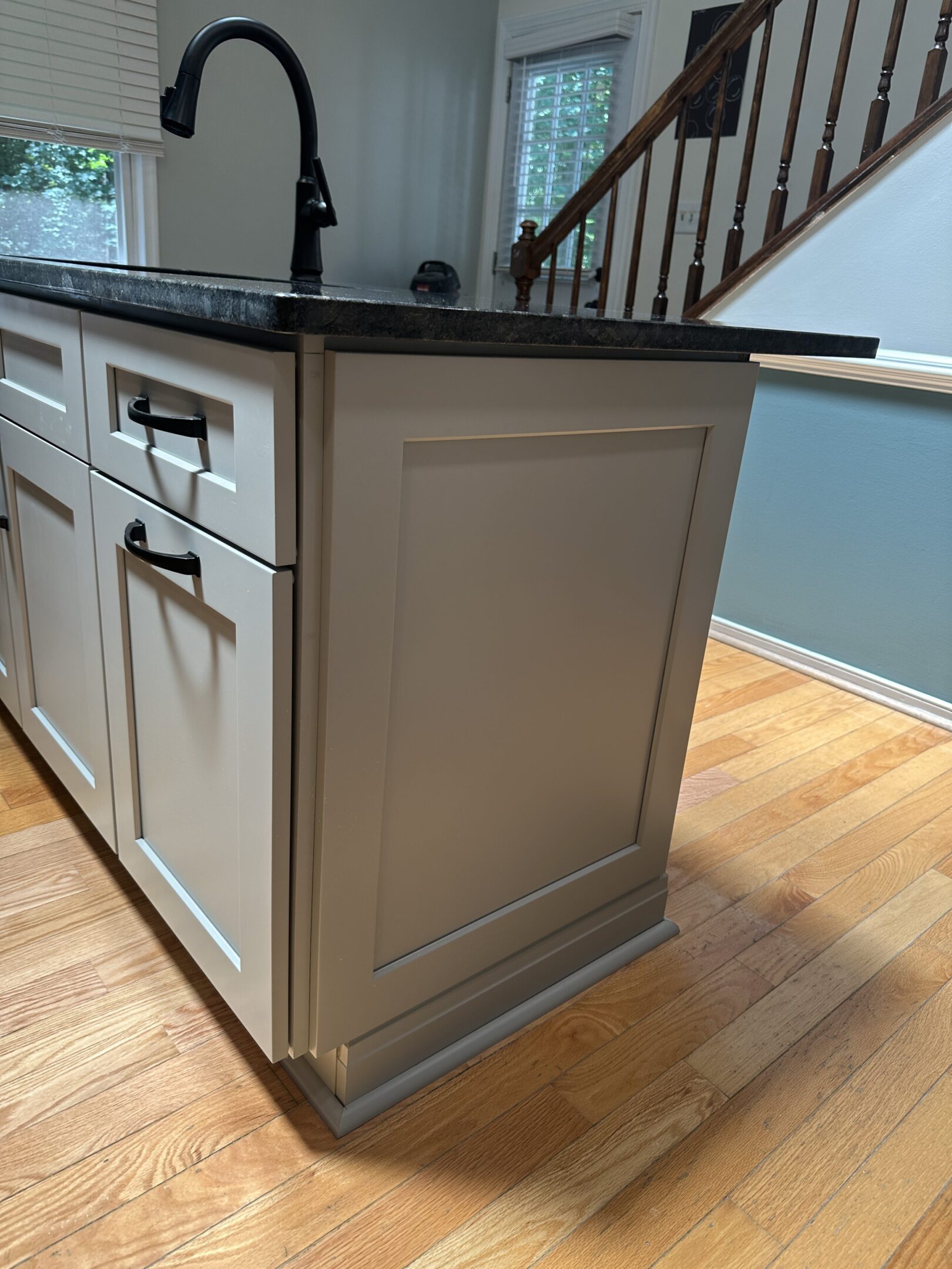 Gray kitchen island with black faucet