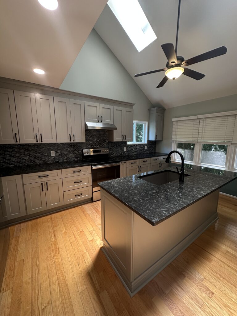 Modern kitchen with island and ceiling fan.