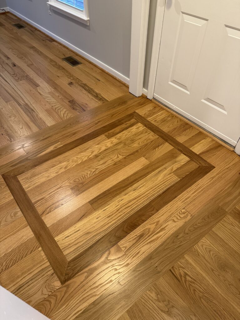 Hardwood floor with decorative wood pattern.