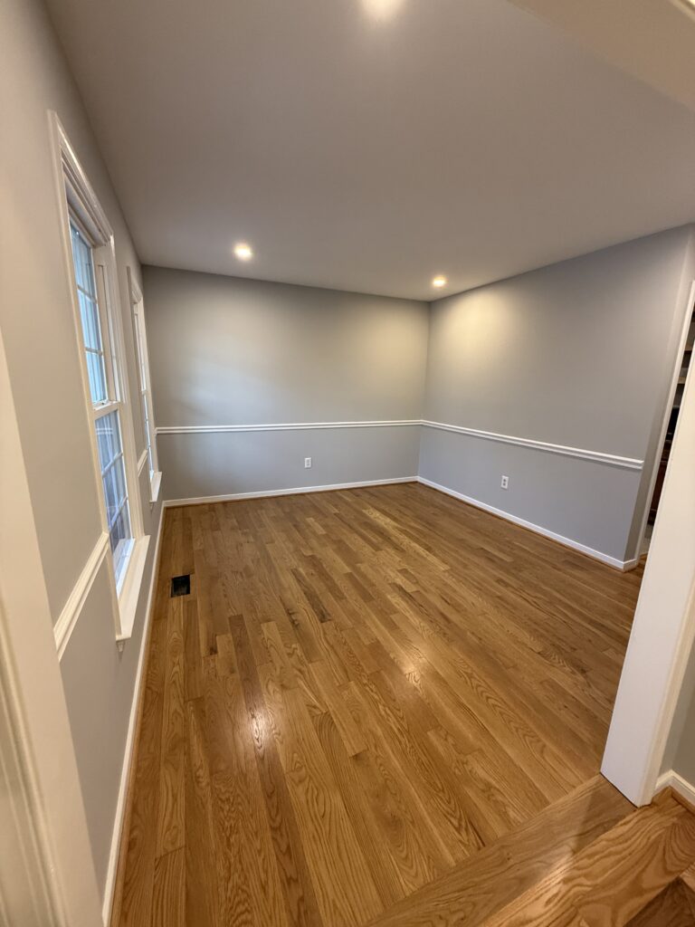 Empty room with wooden floor and gray walls.