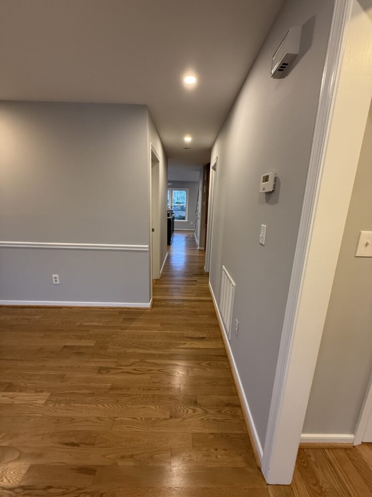 Hallway with wooden floor and gray walls.