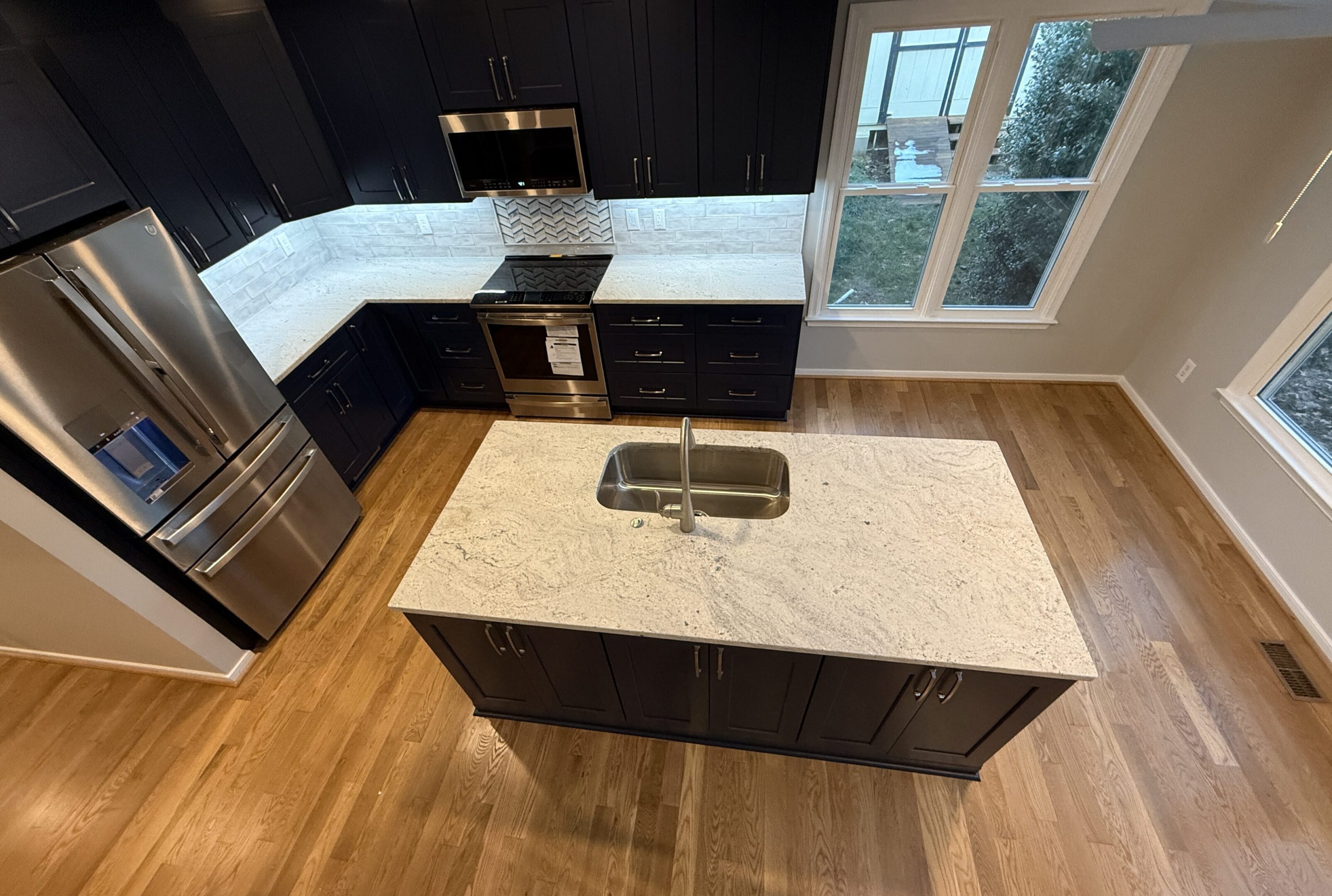 Stainless refrigerator and stove by window