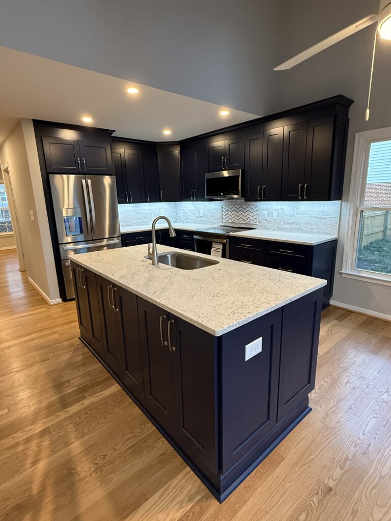 Modern kitchen with dark cabinets and island.