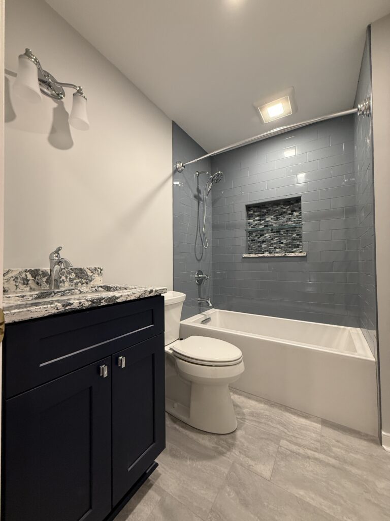 Modern bathroom with blue tiled shower.