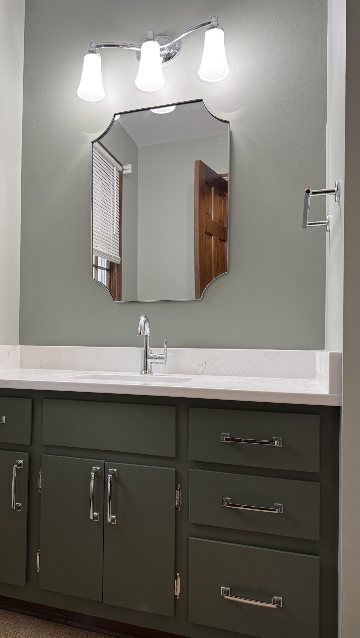 Bathroom with sink, mirror, and light fixture.