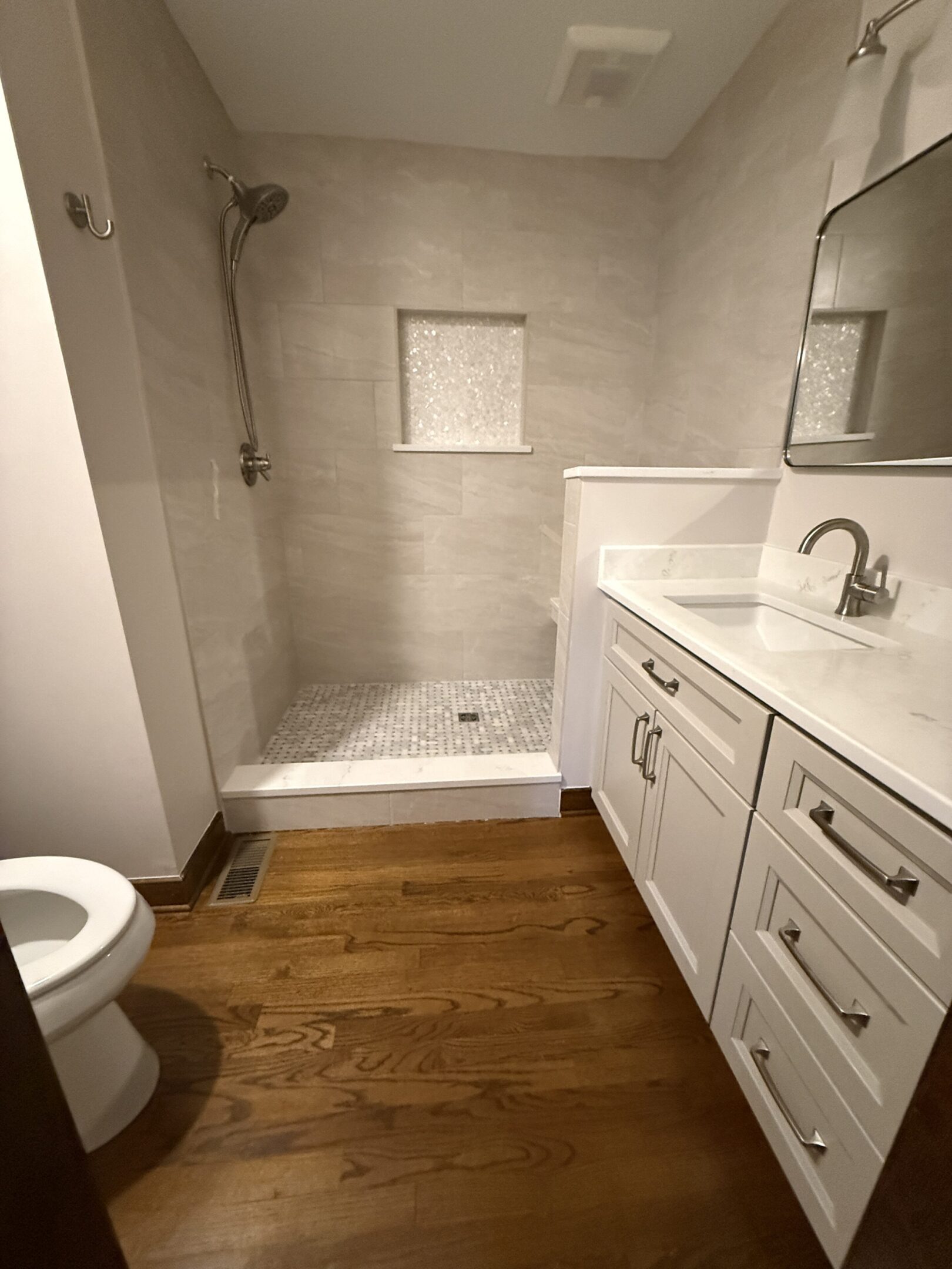 Modern bathroom with shower and wooden floor.