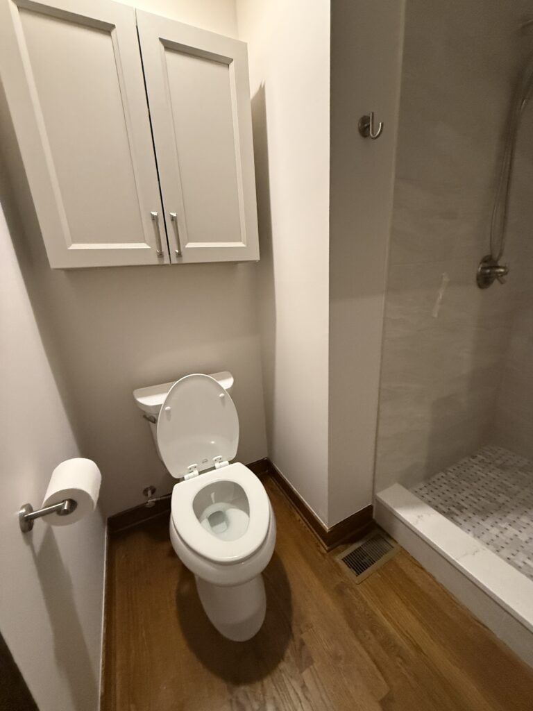 Small bathroom with toilet and shower.