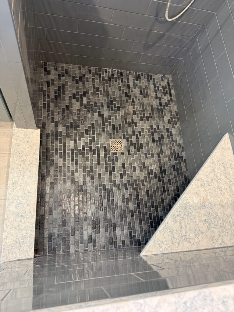 Tiled shower floor with geometric design.