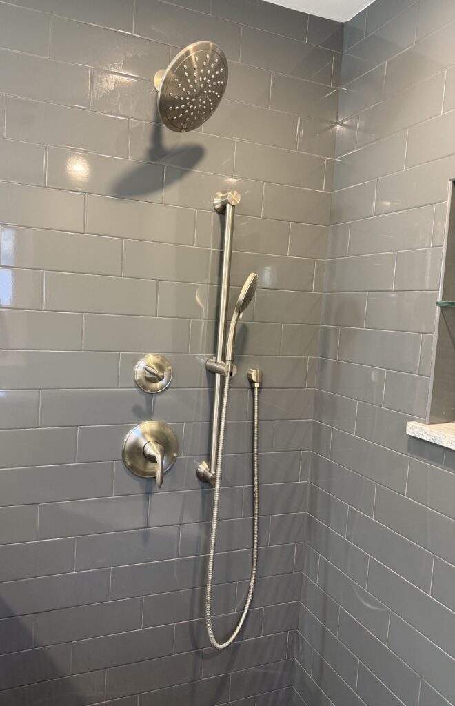 Modern shower with gray tile and fixtures.