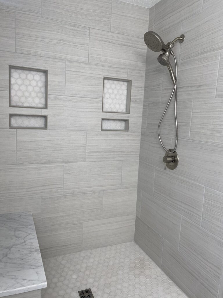 Modern tiled shower with built-in shelves.