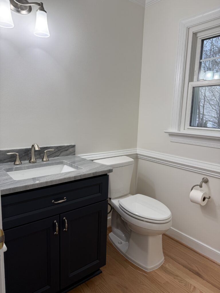 Bathroom with sink, toilet, and window.