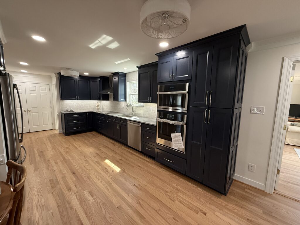 Modern kitchen with dark cabinets and appliances.