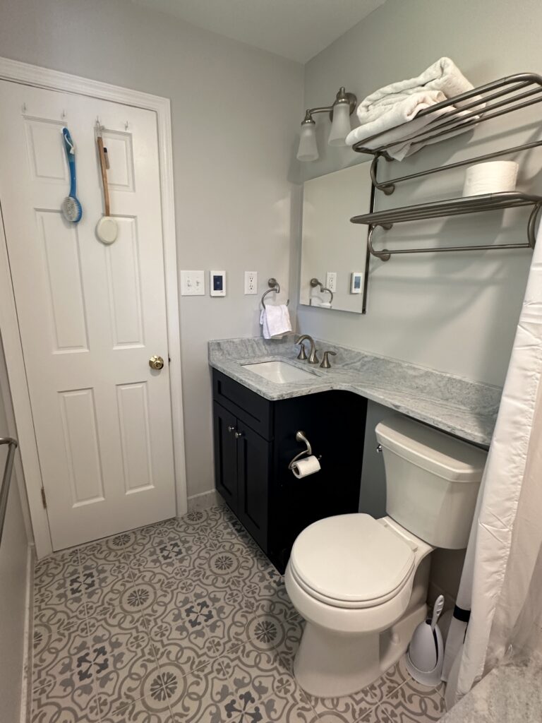 Small bathroom with vanity and patterned floor.