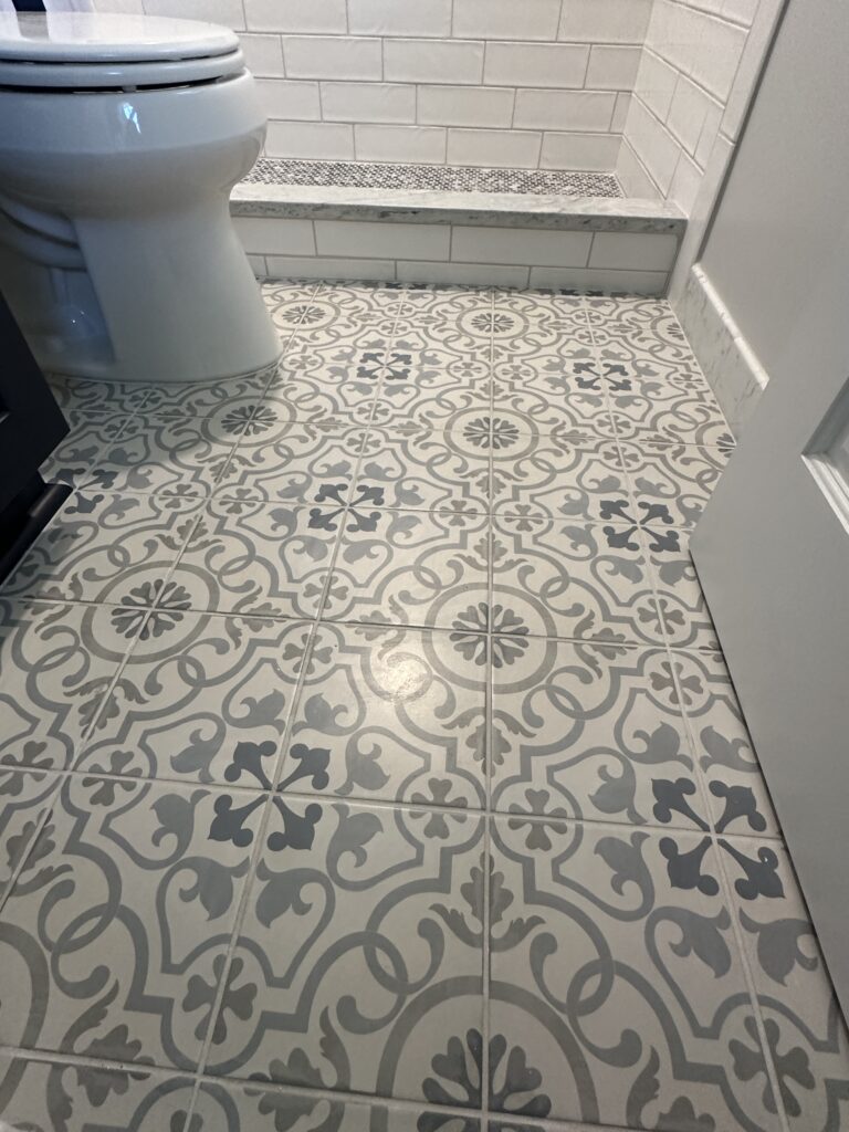 Bathroom with patterned gray and white tiles.