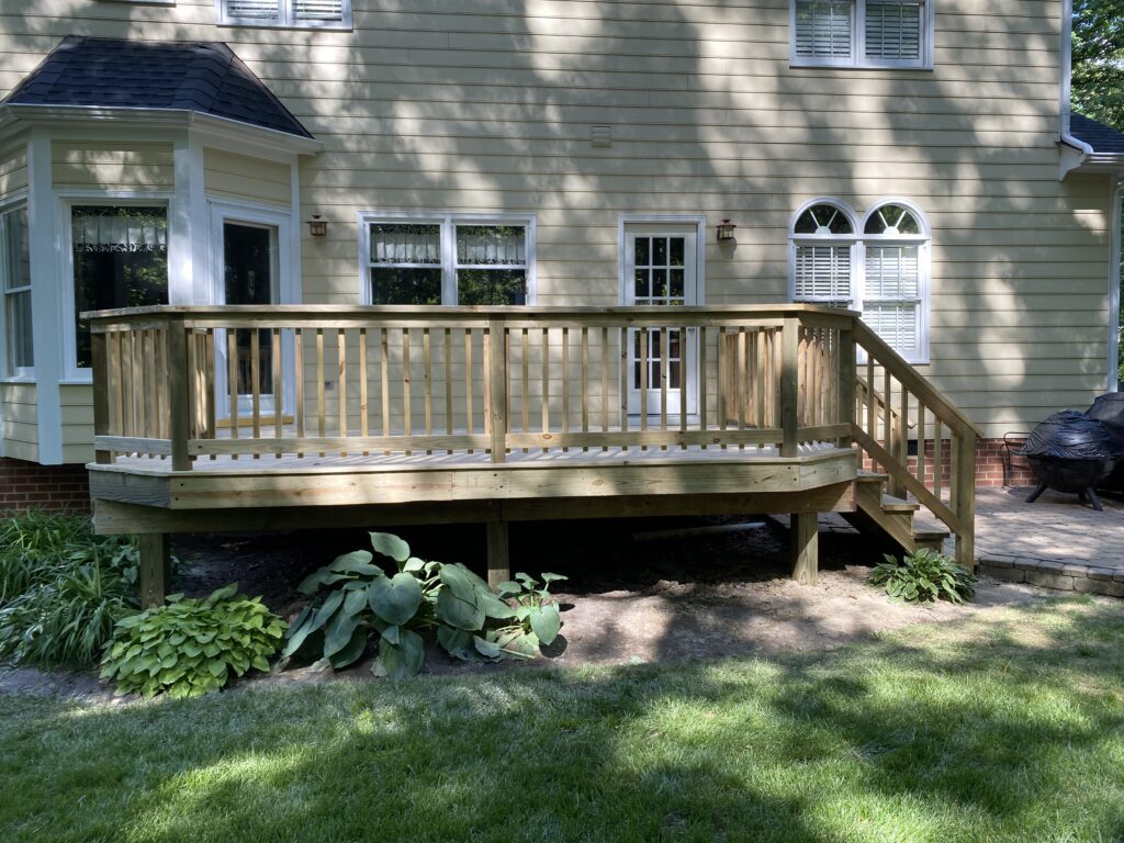Wooden deck with railing and stairs.