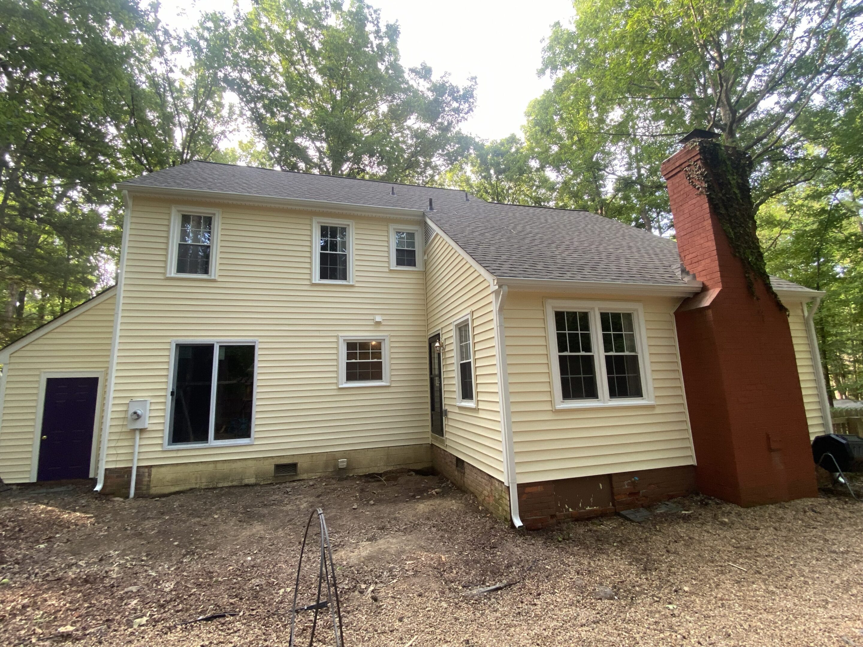 Backyard view of home with large brick chimney