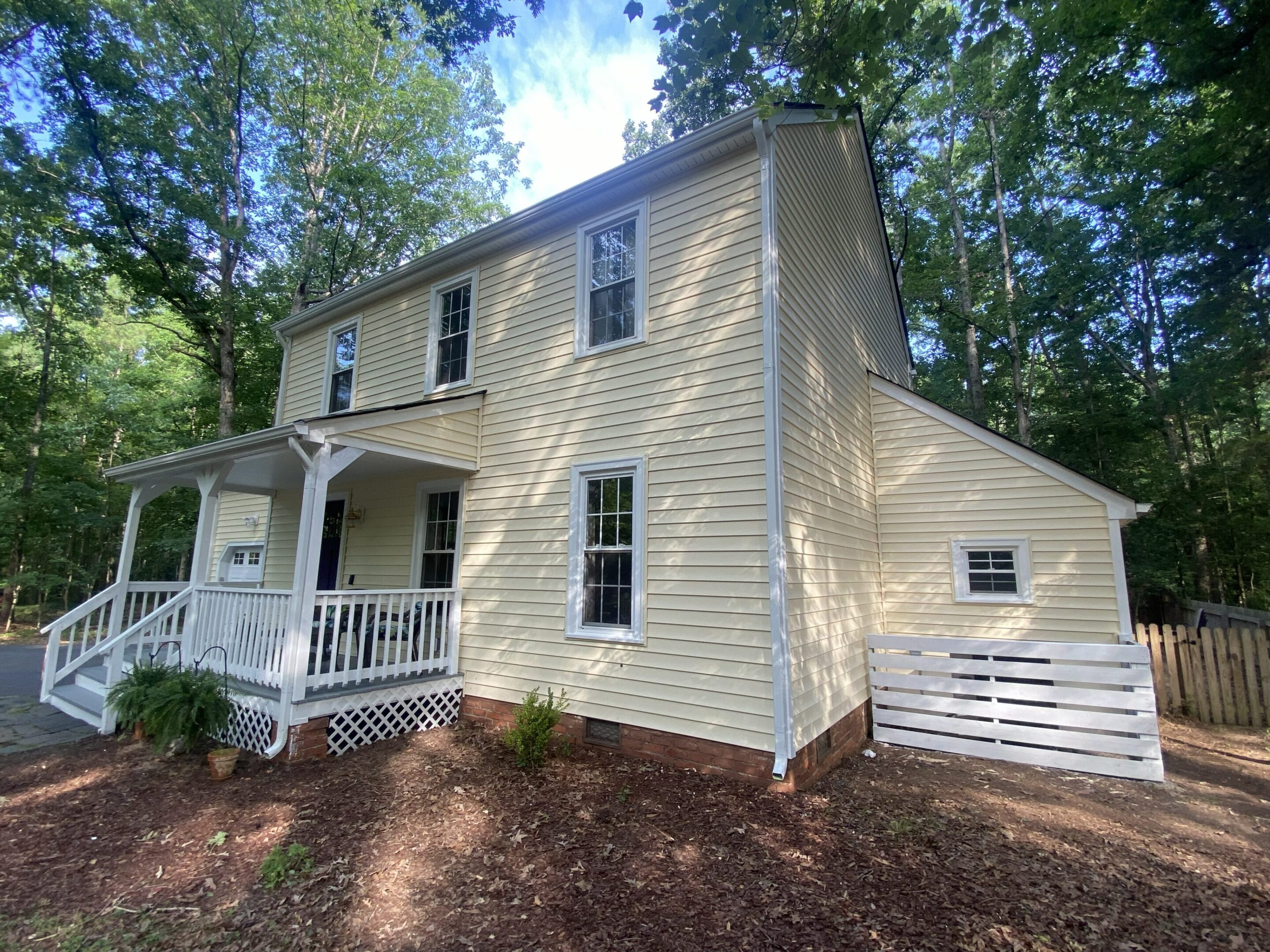 Two-story cream siding house with white porch