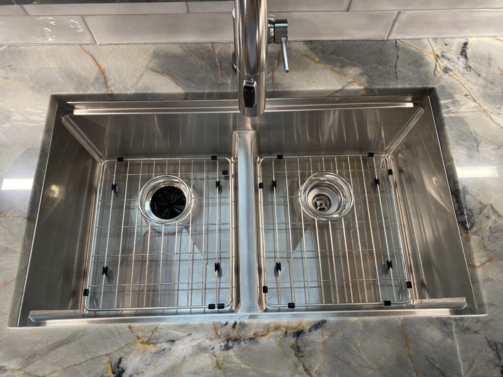 Stainless steel double kitchen sink with grates.