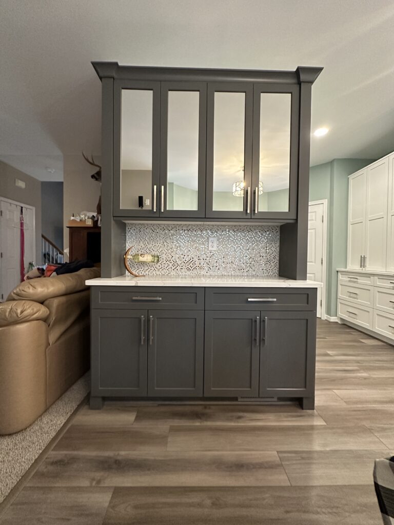 Dark kitchen cabinets with mirrored upper doors.
