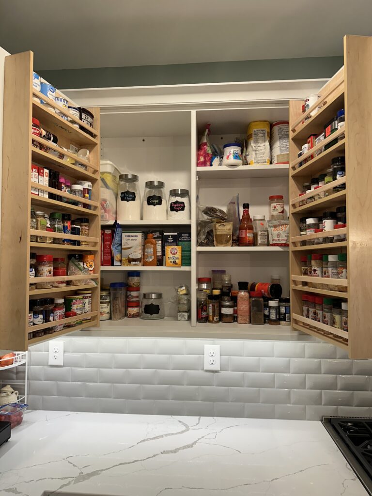Kitchen cabinet with organized spices and condiments.