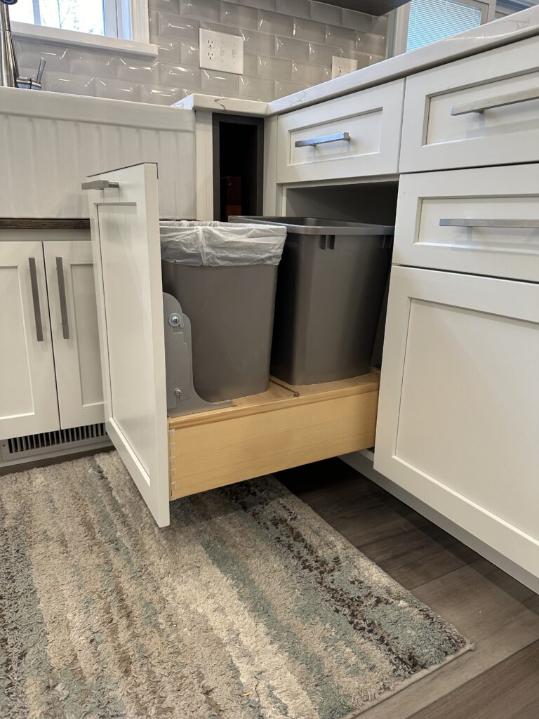 Kitchen cabinet with pull-out trash bins.