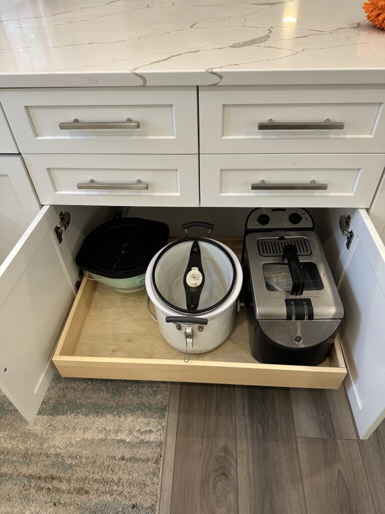 Kitchen drawer with appliances and cookware inside.