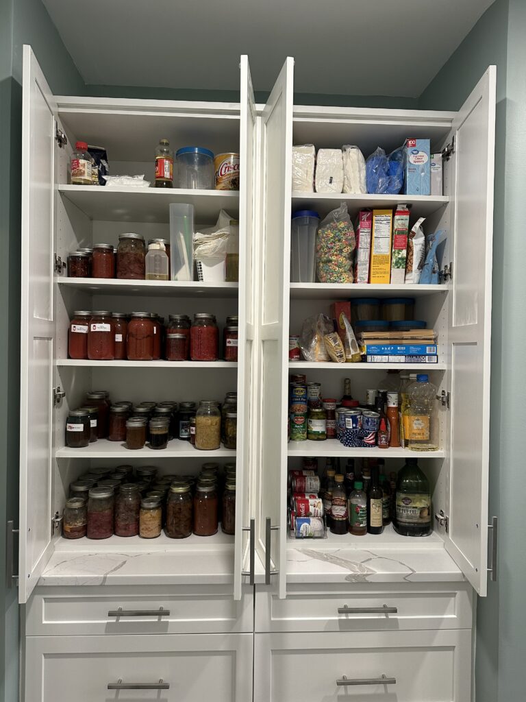 Open pantry cabinet filled with various food items.