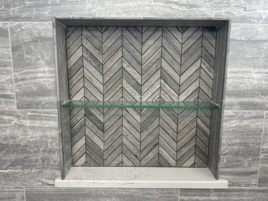Tile niche with chevron pattern and shelf.