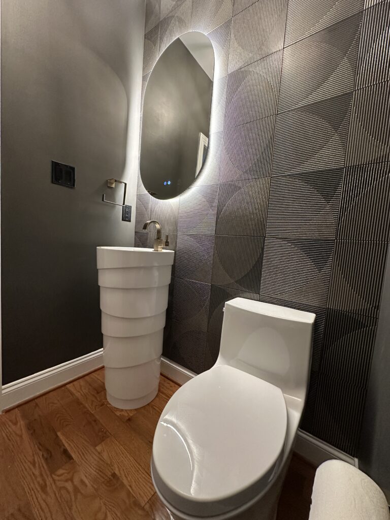 Modern bathroom with unique sink and wallpaper.