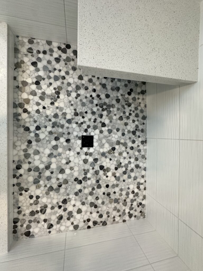 Mosaic tile shower floor with geometric pattern.