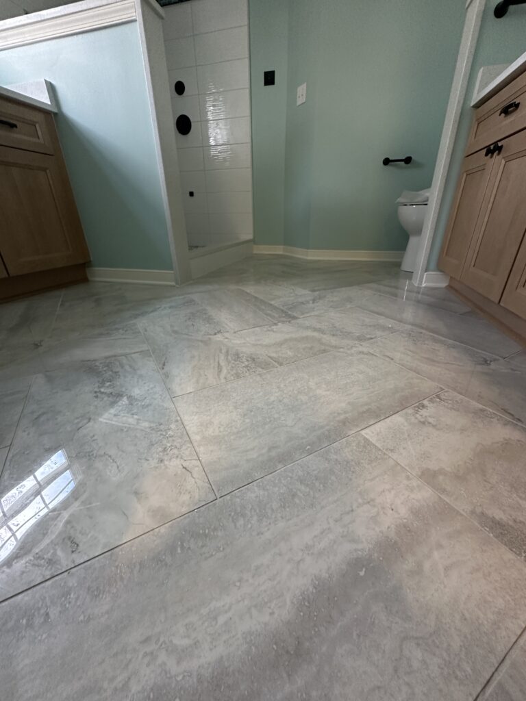 Bathroom with marble floor and wooden cabinets.