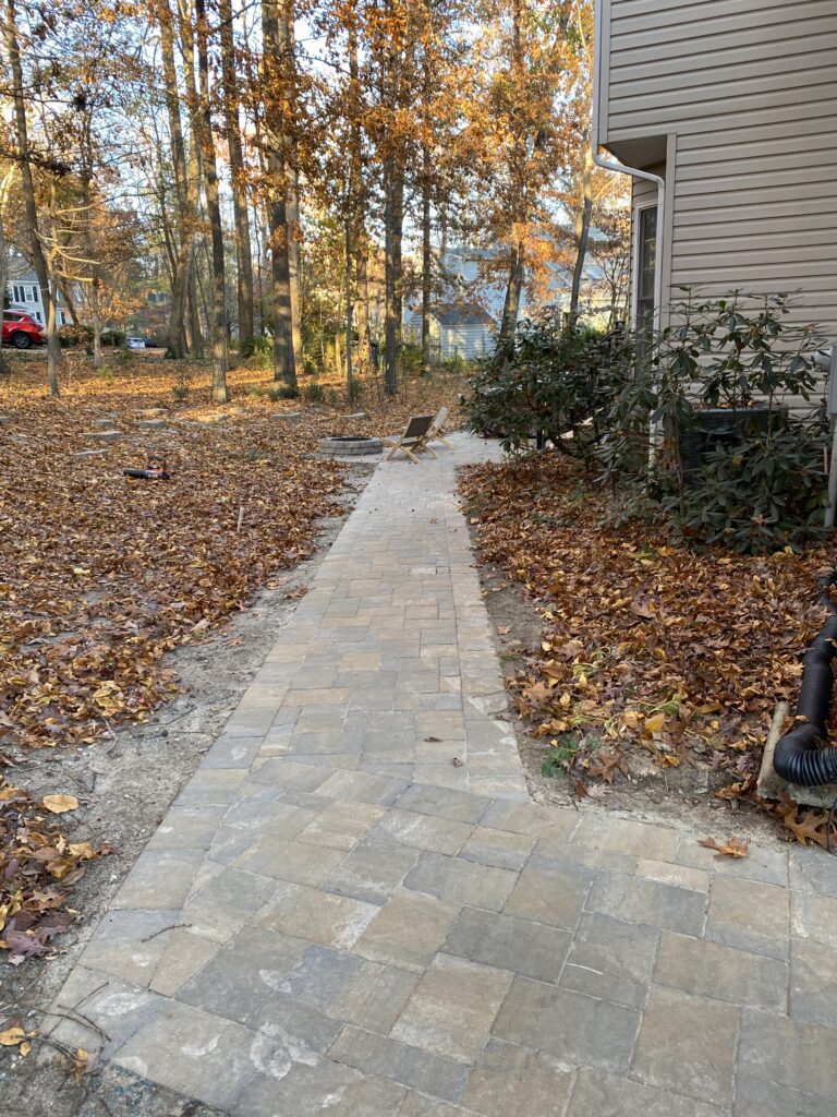 Stone path beside house in autumn forest.
