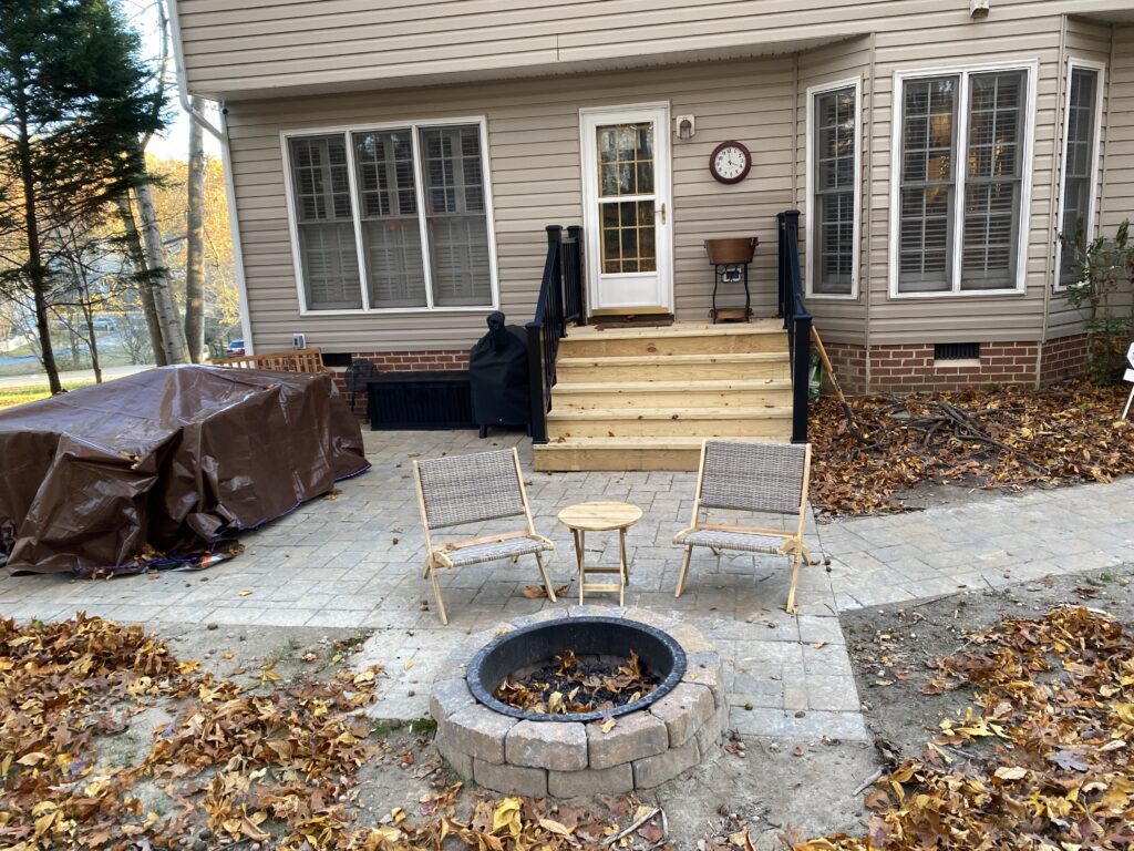 Patio with chairs around a fire pit.