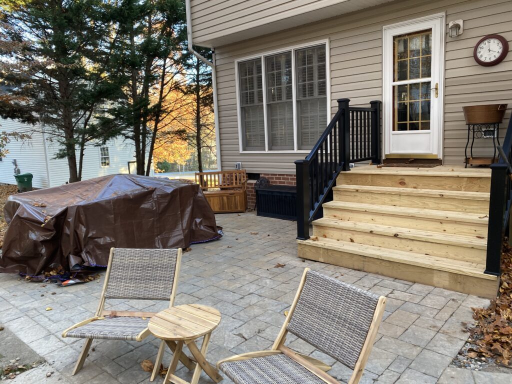Backyard patio with chairs and covered items.